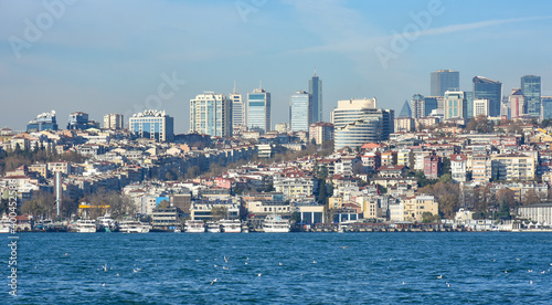 Panoramic view of Istanbul European side from the Asian side. Skyscrapers, hotels and modern offices near old historical tradition buildings. Bosporus on the front of image. © Ersin