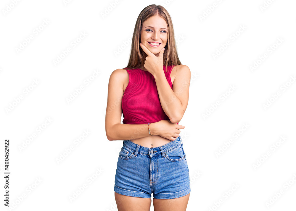 Young beautiful blonde woman wearing elegant summer shirt looking confident at the camera smiling with crossed arms and hand raised on chin. thinking positive. Young beautiful blonde woman wearing elegant summer shirt looking confident at the camera smiling with crossed arms and hand raised on chin. thinking positive.