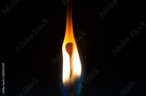 Close-up photo of a burning match in the dark
