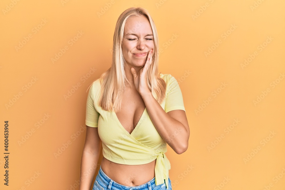 Young blonde girl wearing casual clothes touching mouth with hand with painful expression because of toothache or dental illness on teeth. dentist Young blonde girl wearing casual clothes touching mouth with hand with painful expression because of toothache or dental illness on teeth. dentist