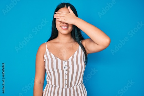 Young beautiful asian girl wearing casual clothes smiling and laughing with hand on face covering eyes for surprise. blind concept.
