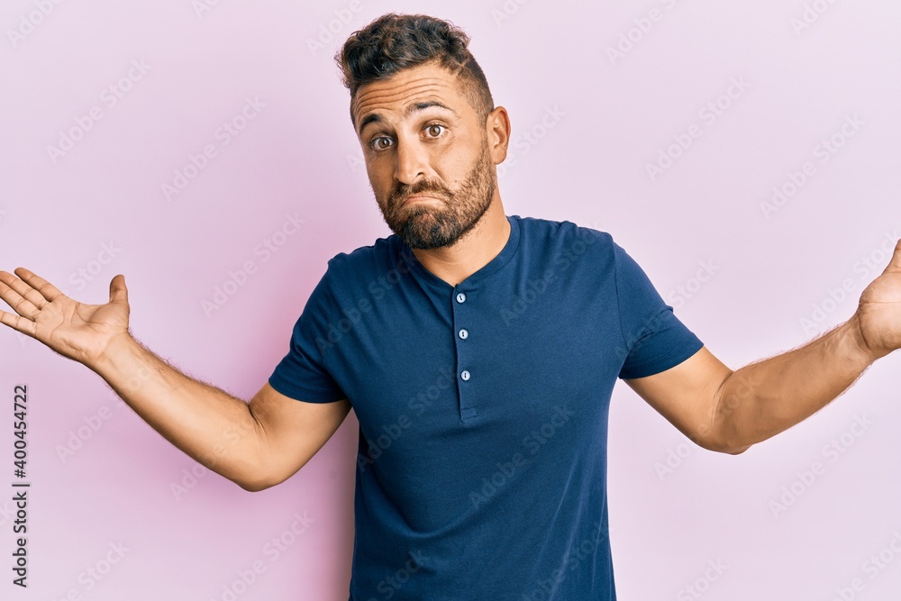 Handsome man with beard wearing casual clothes clueless and confused with open arms, no idea and doubtful face. Handsome man with beard wearing casual clothes clueless and confused with open arms, no idea and doubtful face.