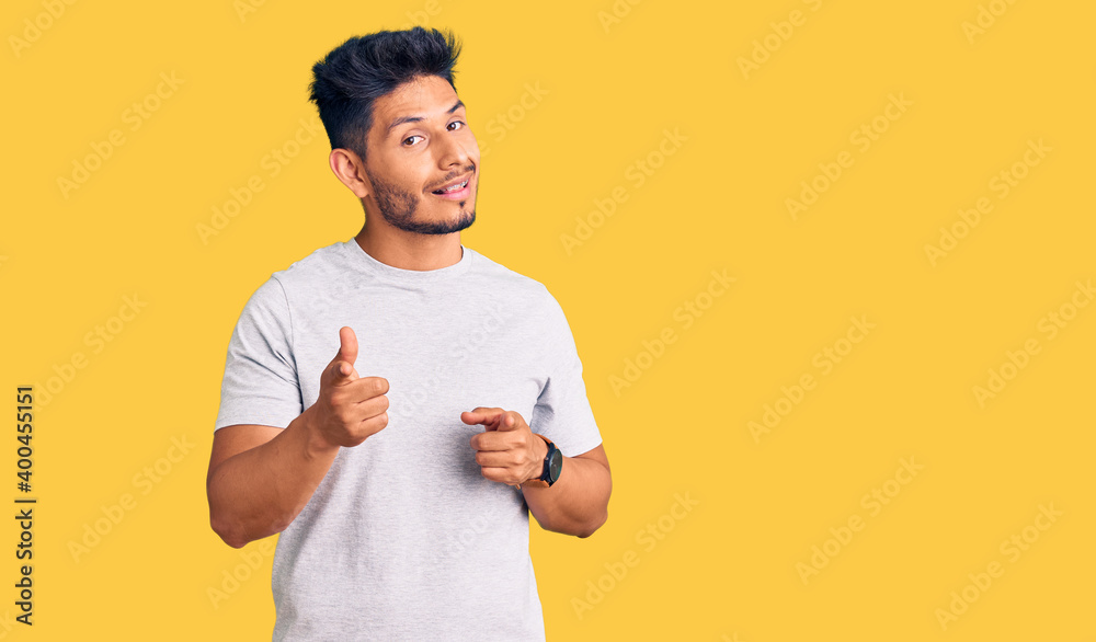 © Krakenimages.com - Handsome latin american young man wearing casual tshirt pointing fingers to camera with happy and funny face. good energy and vibes. © Krakenimages.com - Handsome latin american young man wearing casual tshirt pointing fingers to camera with happy and funny face. good energy and vibes.