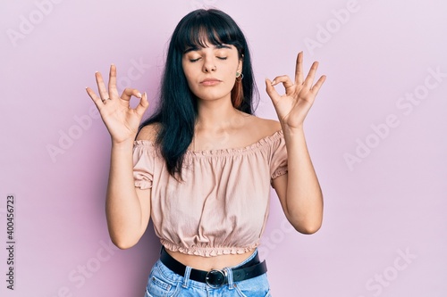 Young hispanic girl wearing casual clothes relax and smiling with eyes closed doing meditation gesture with fingers. yoga concept.