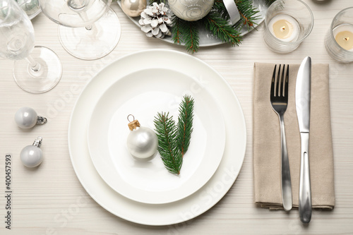 Festive table setting with beautiful dishware and Christmas decor on white wooden background, flat lay