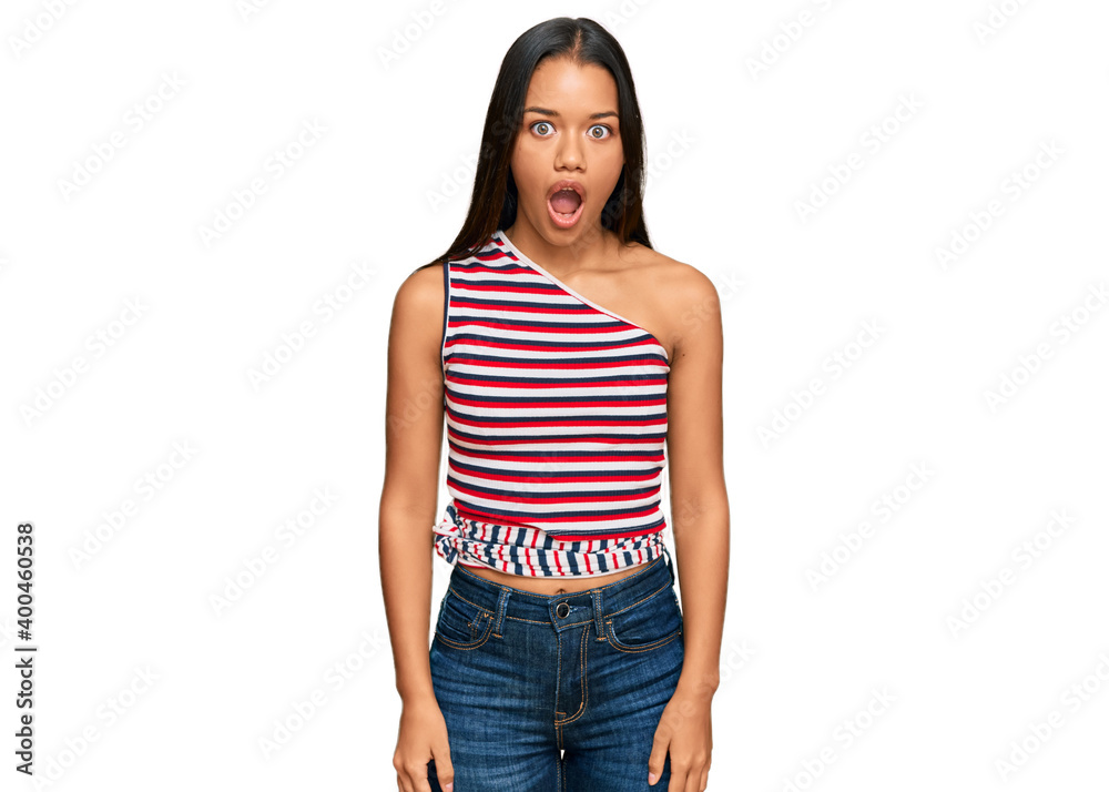 Fototapeta premium Beautiful hispanic woman wearing casual clothes afraid and shocked with surprise expression, fear and excited face.