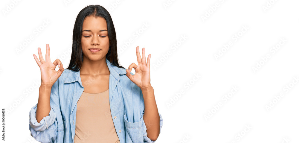 Beautiful hispanic woman expecting a baby showing pregnant belly relax and smiling with eyes closed doing meditation gesture with fingers. yoga concept. Beautiful hispanic woman expecting a baby showing pregnant belly relax and smiling with eyes closed doing meditation gesture with fingers. yoga concept.