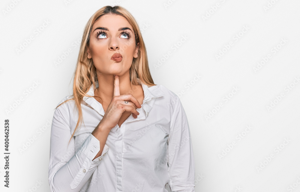 Young caucasian woman wearing casual clothes thinking concentrated about doubt with finger on chin and looking up wondering