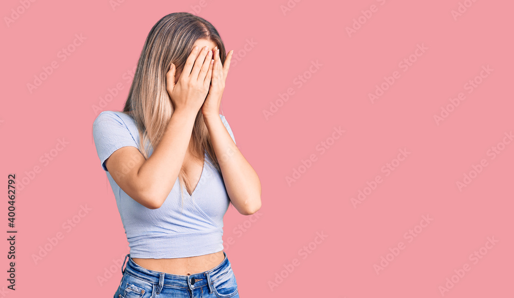 Young beautiful blonde woman wearing casual clothes with sad expression covering face with hands while crying. depression concept. Young beautiful blonde woman wearing casual clothes with sad expression covering face with hands while crying. depression concept.
