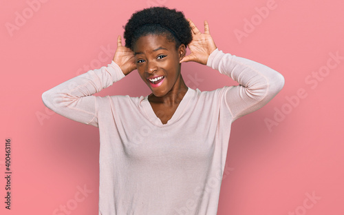 Young african american girl wearing casual clothes smiling cheerful playing peek a boo with hands showing face. surprised and exited