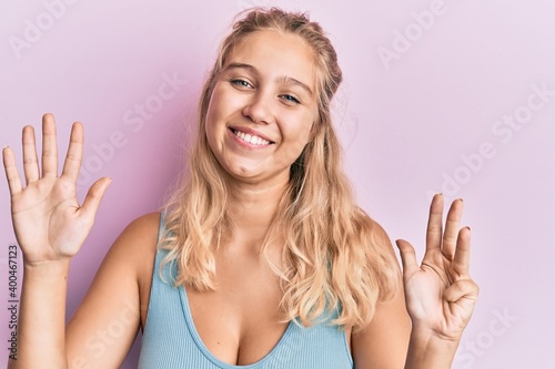 Young blonde girl wearing casual clothes showing and pointing up with fingers number nine while smiling confident and happy.