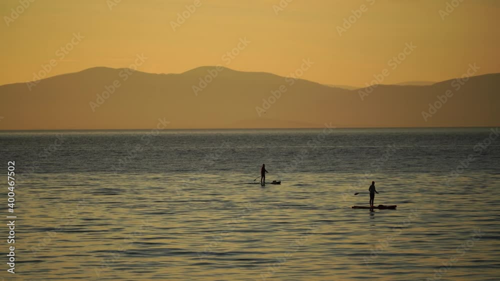 Sea landscape with silhouettes of the Islands and the people on the SAP boards. Sea landscape with silhouettes of the Islands and the people on the SAP boards.