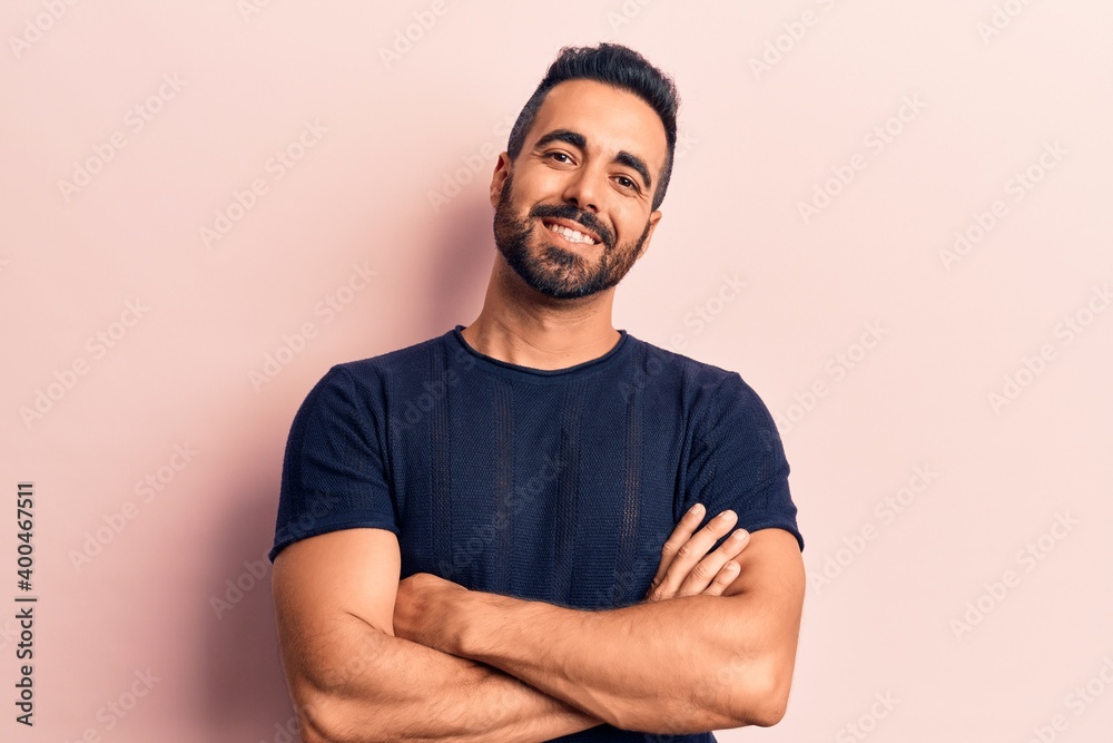 Young hispanic man wearing casual clothes happy face smiling with crossed arms looking at the camera. positive person. Young hispanic man wearing casual clothes happy face smiling with crossed arms looking at the camera. positive person.