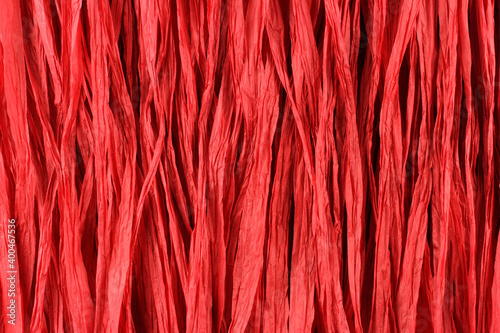 Background - red paper raffia strips situated in parallel lines.