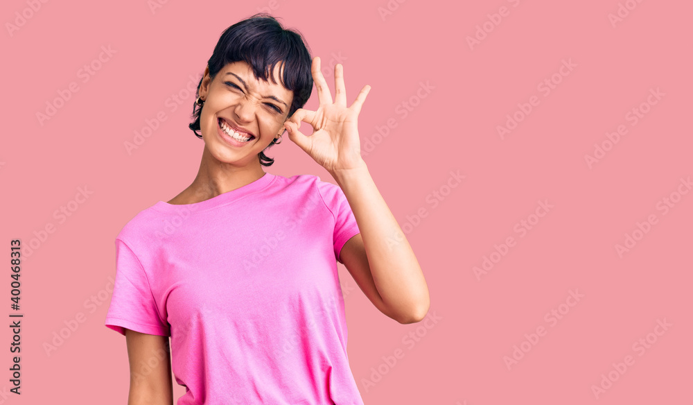 Young brunette woman with short hair wearing casual clothes smiling positive doing ok sign with hand and fingers. successful expression. Young brunette woman with short hair wearing casual clothes smiling positive doing ok sign with hand and fingers. successful expression.