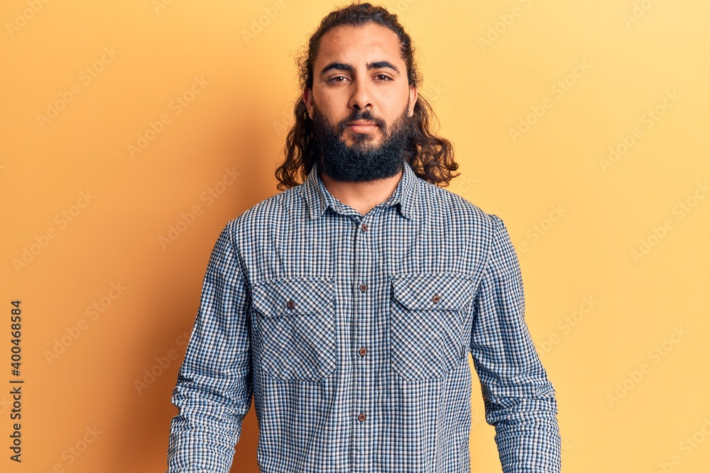 Young arab man wearing casual clothes with serious expression on face. simple and natural looking at the camera. Young arab man wearing casual clothes with serious expression on face. simple and natural looking at the camera.