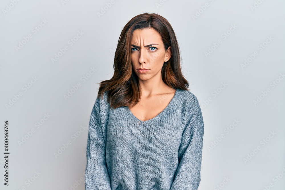 Young brunette woman wearing casual winter sweater skeptic and nervous, frowning upset because of problem. negative person. Young brunette woman wearing casual winter sweater skeptic and nervous, frowning upset because of problem. negative person.