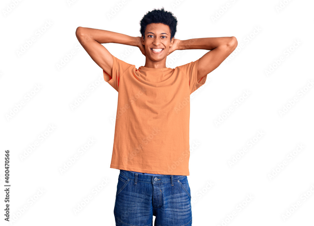 Young african american man wearing casual clothes relaxing and stretching, arms and hands behind head and neck smiling happy Young african american man wearing casual clothes relaxing and stretching, arms and hands behind head and neck smiling happy