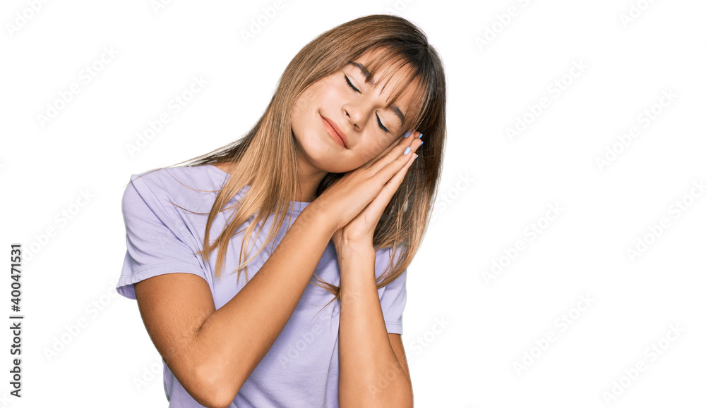 Teenager caucasian girl wearing casual clothes sleeping tired dreaming and posing with hands together while smiling with closed eyes. Teenager caucasian girl wearing casual clothes sleeping tired dreaming and posing with hands together while smiling with closed eyes.