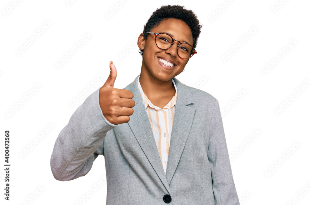 Young african american woman wearing business clothes doing happy thumbs up gesture with hand. approving expression looking at the camera showing success. Young african american woman wearing business clothes doing happy thumbs up gesture with hand. approving expression looking at the camera showing success.