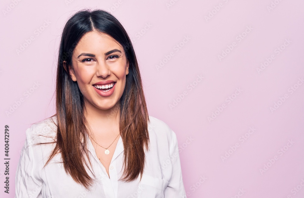 Young beautiful brunette woman wearing elegant shirt standing over isolated pink background with a happy and cool smile on face. Lucky person. Young beautiful brunette woman wearing elegant shirt standing over isolated pink background with a happy and cool smile on face. Lucky person.