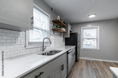 Kitchen with gray cabinets, white subway tile backsplash and wood accents 