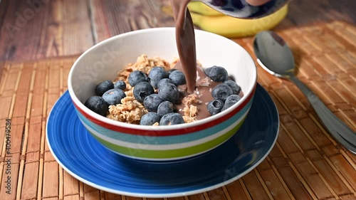 serving bowl of cereal with chocolate almond milk and blueberries