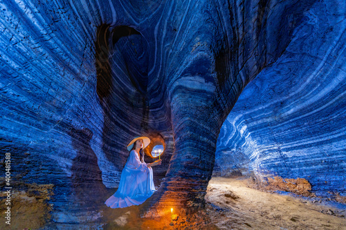  Asian woman in a white dress visits a blue cave in Tak Province, Thailand. photo