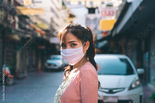 Happy asian adult woman tan skin wear mask on face for new normal.