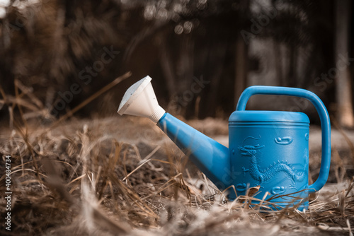 Blue watering can in the garden