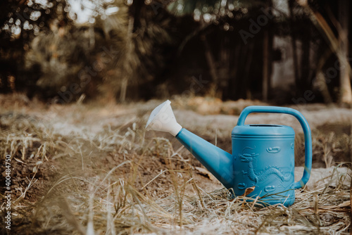 Blue watering can in the garden