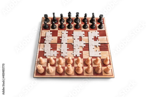 Rivalry and unification concept. Word "Life" laid out by mosaic puzzle on chessboard with two chess teams against white background. Life as game concept. Life is puzzle. Rivalry and unification