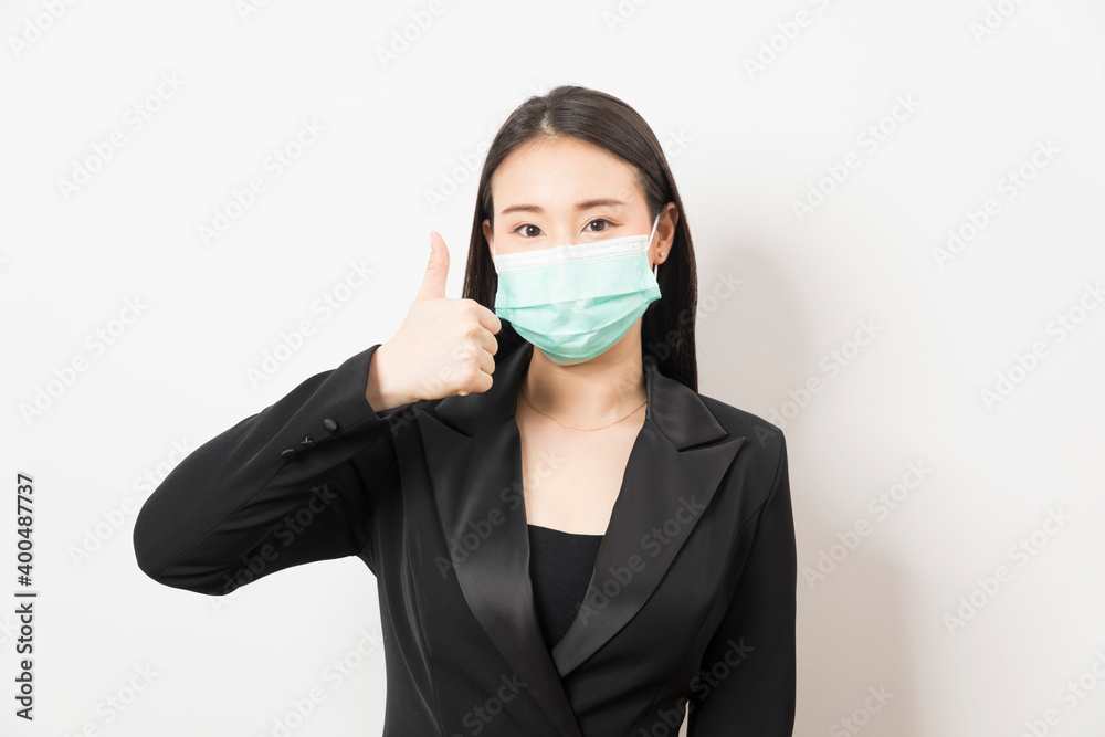 Portrait young Asian business woman in suit wearing face mask on white isolated background. Portrait young Asian business woman in suit wearing face mask on white isolated background.