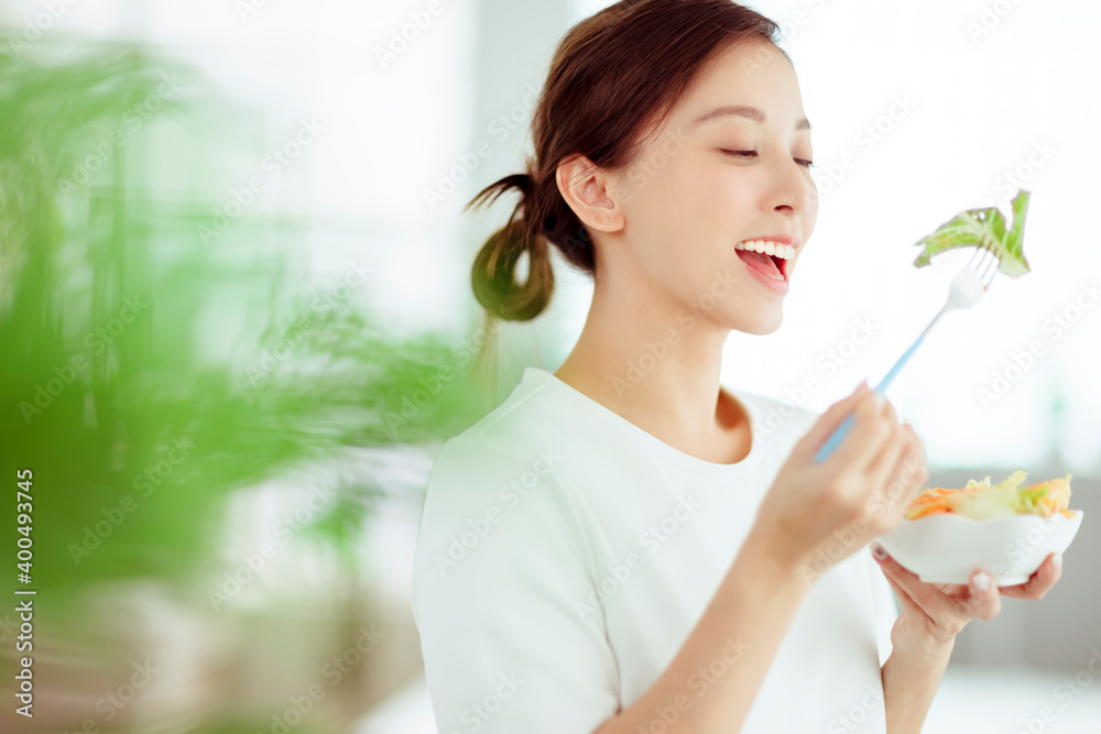 Young happy woman eating healthy salad at home Young happy woman eating healthy salad at home