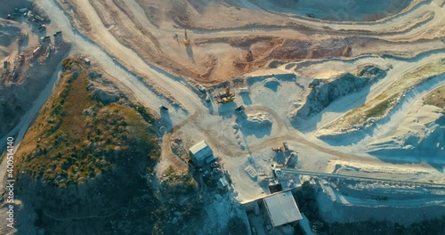 Aerial view of opencast mining quarry with lots of machinery at work - view from above. 