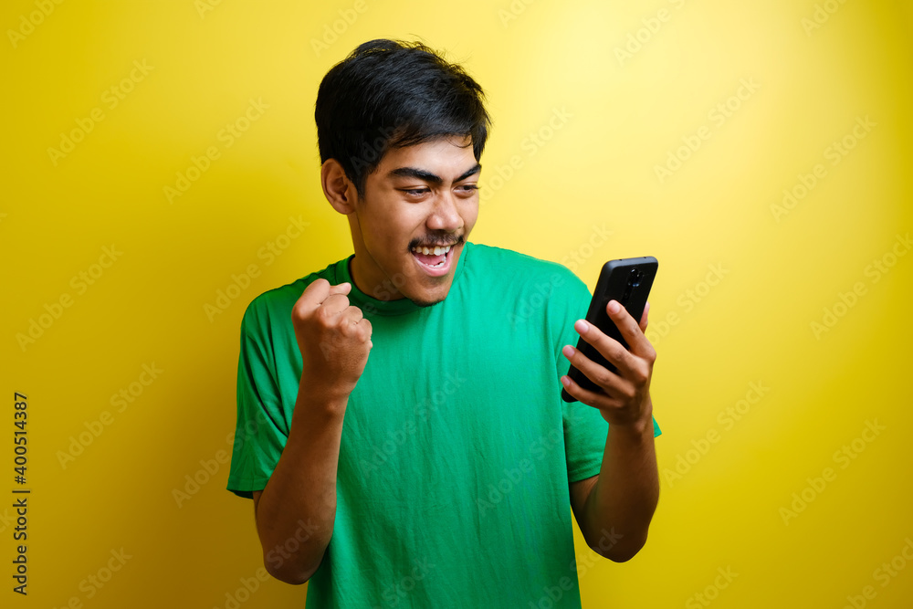 Attractive young Asian man have good news on his phone Attractive young Asian man have good news on his phone