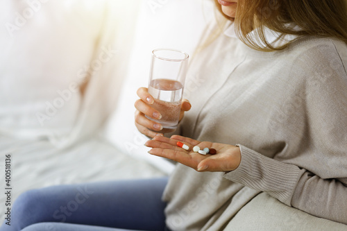 Close-up woman holding pills time to take medications, cure for headache. Medicine concept during self isolation and Coronavirus pandemic