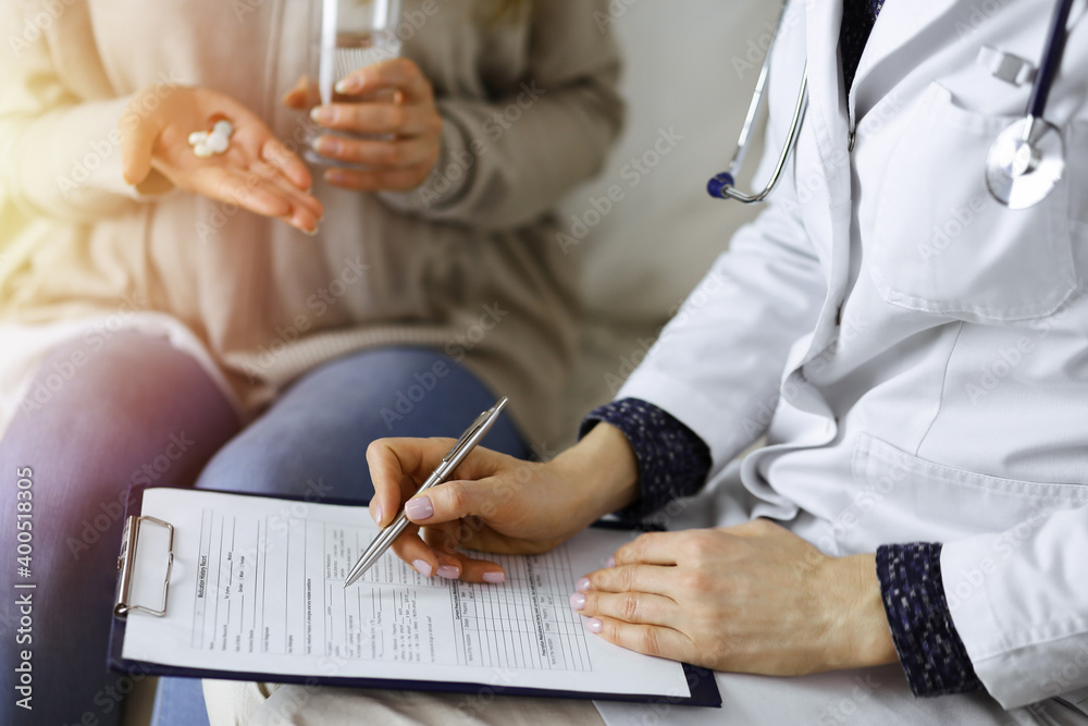 Close-up of woman-doctor and patient discussing current health examination while sitting indoors. Stay at home concept during Coronavirus pandemic and self isolation quarantine. Covid 2019 Close-up of woman-doctor and patient discussing current health examination while sitting indoors. Stay at home concept during Coronavirus pandemic and self isolation quarantine. Covid 2019
