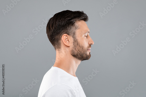 Side view of middle-aged man over grey background