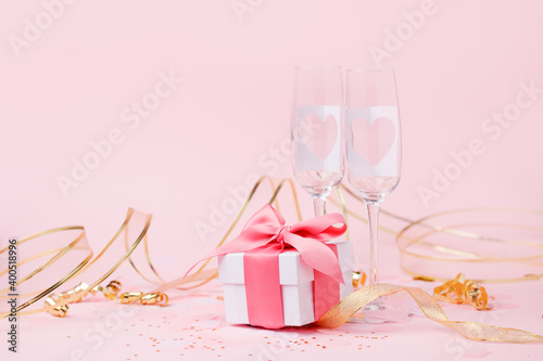 Saint Valentine days background - elegant luxury gift box and pair of champagne glasses with hearts on pink  copy space for your greering text  romance party card  seasonal holiday