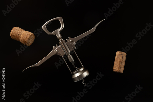 Cuadro en lienzo Flying metal corkscrew and wine corks on the black background