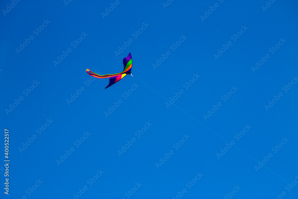 Colorful flying kite fly in the blue sky