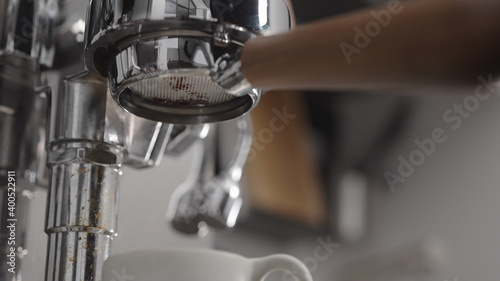 low angle shot of coffee extraction with naked portafilter into white cup