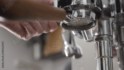 low angle flush coffee machine before extraction with naked portafilter into white cup