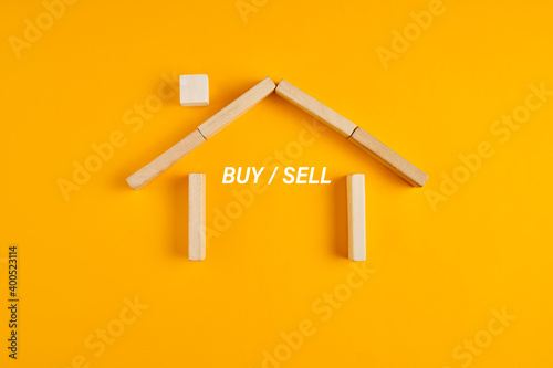 House made of wooden blocks with buy or sell options. Decision of buying or selling a real estate.