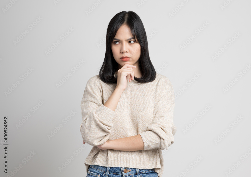 Asian female standing and thinking on isolated white background. Asian female standing and thinking on isolated white background.