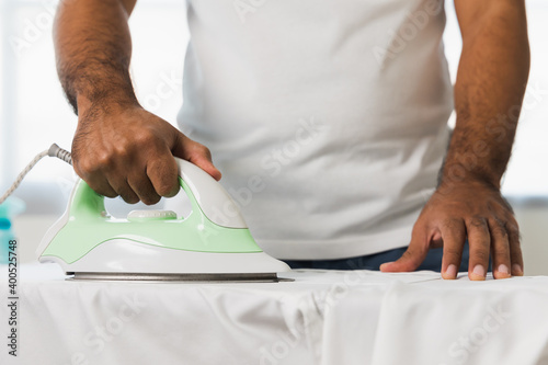 A man's hand using an iron. Iron the garment to make it smooth. Pictures about housework