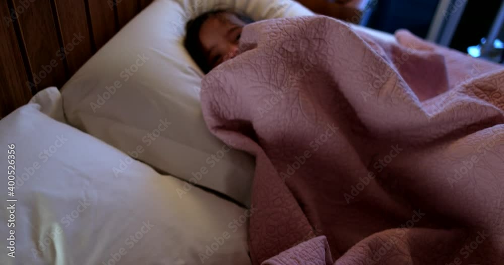 Happy little brother and sister lying in bed laughing and playing together before sleep at night Happy little brother and sister lying in bed laughing and playing together before sleep at night