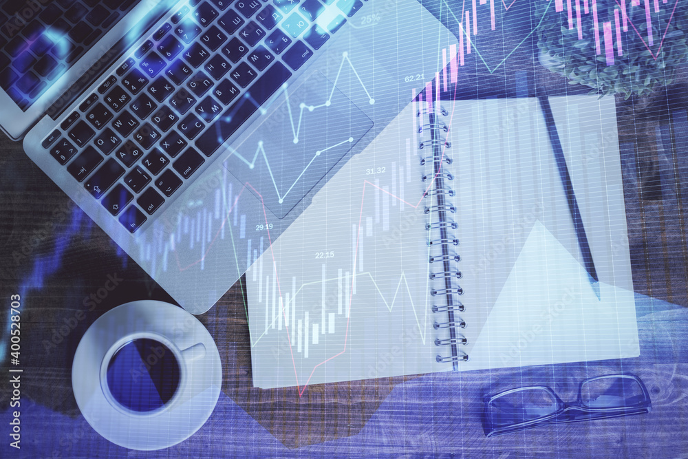 Financial market graph and top view computer on the desktop background. Double exposure. Investment concept. Financial market graph and top view computer on the desktop background. Double exposure. Investment concept.