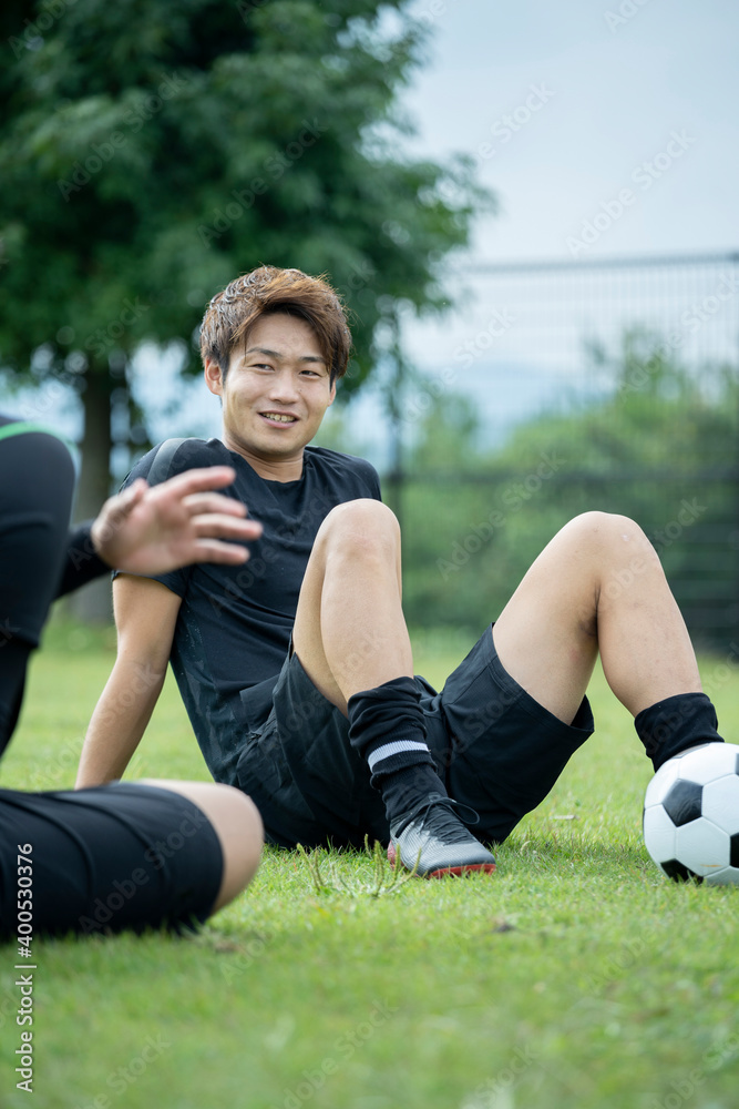 Naklejka premium 公園でサッカーをする若い男性